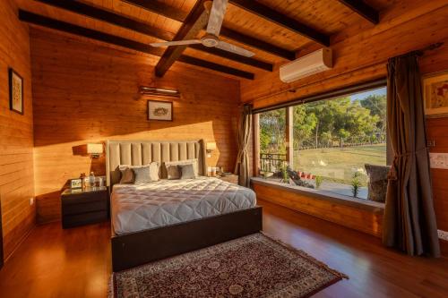 a bedroom with a bed and a large window at SaffronStays Timber Crest in Dehradun