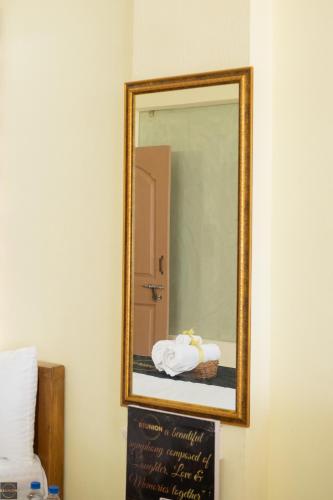 a mirror on a wall with a sign in front of it at Reunion Ocean Waves - Beach House in Udupi