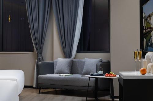 a living room with a couch and a table at 悦蓝里s酒店成都春熙路宽窄巷子店 in Chengdu