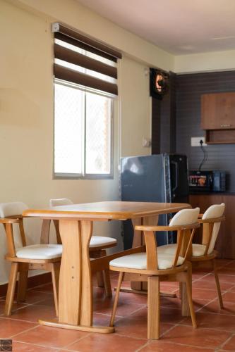 a wooden table and chairs in a kitchen at Reunion Ocean Waves - Beach House in Udupi