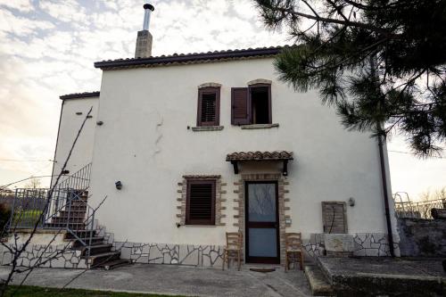 a white house with a staircase in front of it at La Campagna del Benessere in Gildone