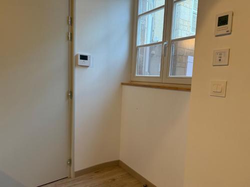 a room with a window and a white wall at La Loge Lingonne in Langres
