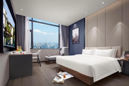 a bedroom with a large white bed and a desk at 悦蓝里s酒店成都春熙路宽窄巷子店 in Chengdu