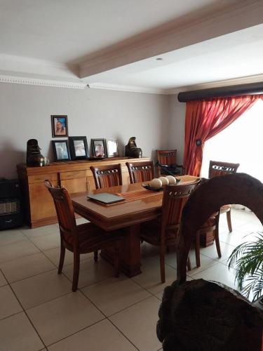 a dining room with a wooden table and chairs at Mbele's home stay in Bloemfontein