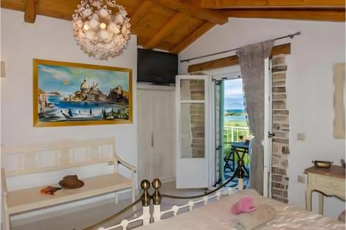 a bedroom with a chandelier and a bed in a room at Siorra Angelina Villa in Perítheia
