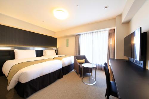 a hotel room with two beds and a flat screen tv at Richmond Hotel Premier Asakusa International in Tokyo