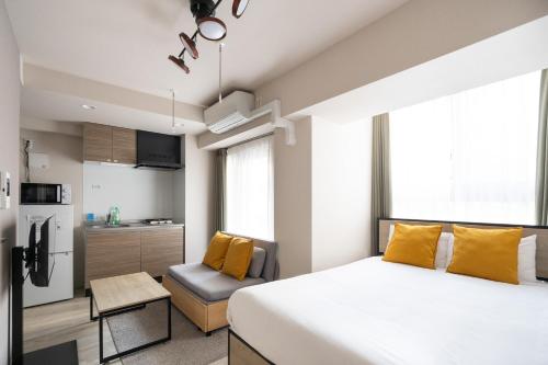 a bedroom with a large bed and a kitchen at Lafesta Higashikomagata in Tokyo