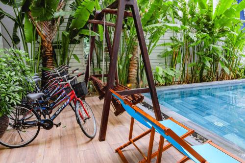 a group of bikes parked next to a swimming pool at Palm Riverside Boutique in Hoi An
