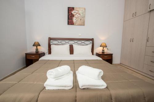 - une chambre avec un grand lit et 2 serviettes blanches dans l'établissement Baia Blu Apartments, à Sivota