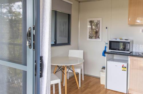 a small kitchen with a table and a microwave at BIG4 Bridgetown in Bridgetown