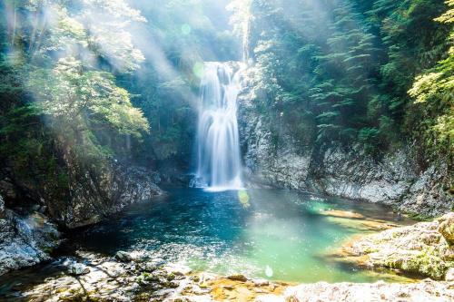 a waterfall in the middle of a river at 宿屋まてまて Villa Mate Mate in Sawara