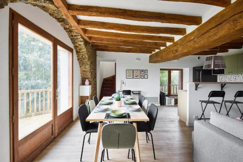 une salle à manger avec une longue table et des chaises dans l'établissement Charmante Maison - Le Cœur des Hommes - Wifi, Balnéo, Hammam, à Beaupréau