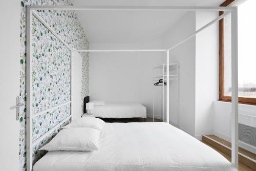 une chambre blanche avec un lit et une fenêtre dans l'établissement Charmante Maison - Le Cœur des Hommes - Wifi, Balnéo, Hammam, à Beaupréau