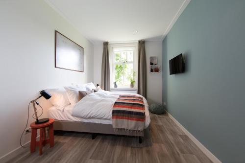 a bedroom with a bed and a window at B&B De Beiert in Delden