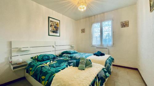 sypialnia z dwoma łóżkami w pokoju w obiekcie Rendez-vous au soleil de Provence - gite 4 personnes 80m2 - coin jardin - climatisation w mieście Cheval-Blanc