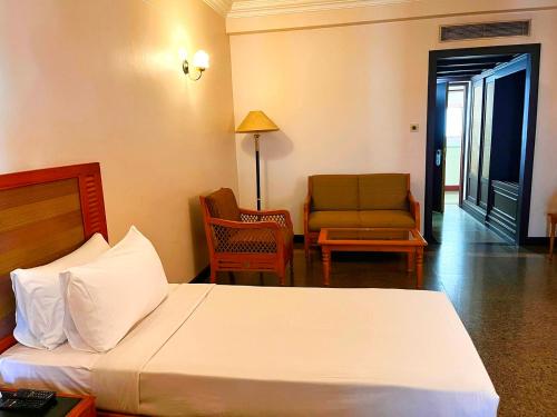 a hotel room with a bed and a chair at Hyson heritage calicut in Kozhikode