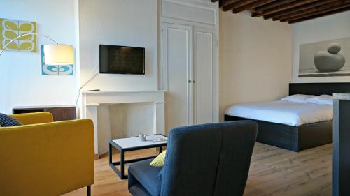 een woonkamer met een bed en een bank bij Little Suite - Héloise in Lille