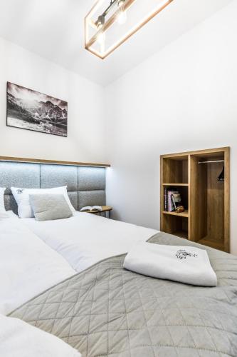 two beds in a room with white walls at Apartamenty Krokusowa Dolina in Kościelisko