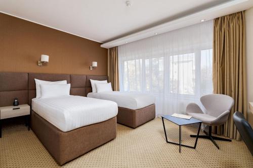 a hotel room with two beds and a window at Crystal Palace Hotel in Bucharest