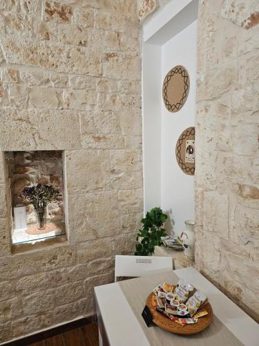 a room with a table and a stone wall at PietraRosa Apartment in Triggianello