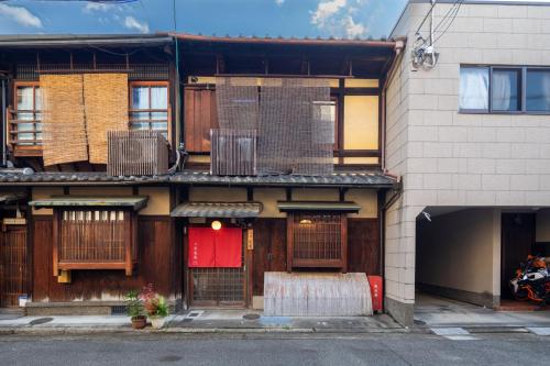 a building with wooden doors and a red door at Nijo-Ouan in Kyoto