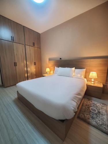 a large white bed in a bedroom with two lamps at Brighton Guest House and Cafe in Addis Ababa