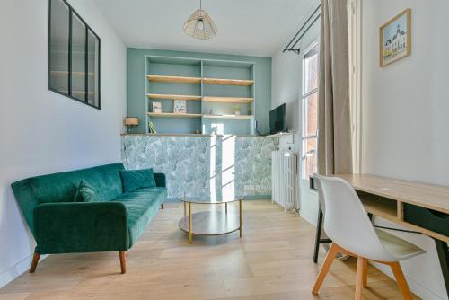 un salon avec un canapé vert et une table dans l'établissement Le Temple, authentique et charmant, à Limoges