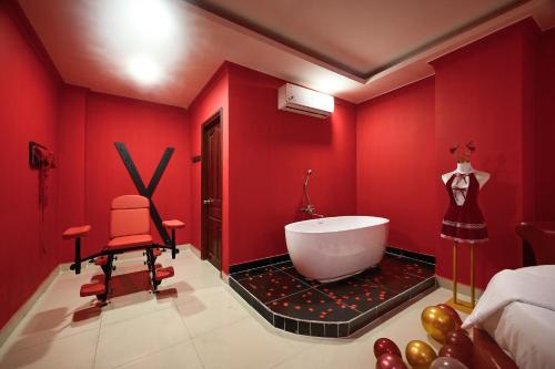 a red bathroom with a tub and a red wall at Trung Mai Hotel - Nguyễn Thái Bình in Ho Chi Minh City