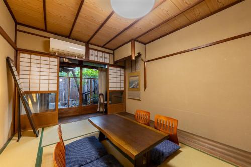 a dining room with a wooden table and chairs at Nijo-Ouan in Kyoto