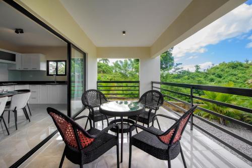 a balcony with a table and chairs and a kitchen at Casa Vista Mar in Río San Juan