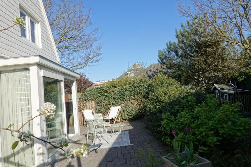 a porch of a house with chairs and plants at Ithaka Beach House, unieke plek met vrij parkeren! in Noordwijk
