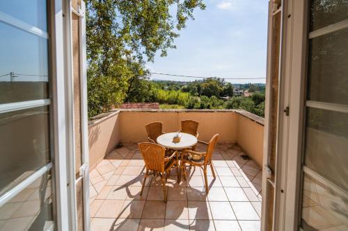 a patio with a table and chairs on a balcony at Villa Tereza in Čilipi