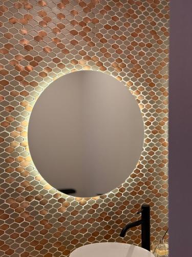 a mirror in a bathroom with a sink at Shiki Villa Beppu in Beppu