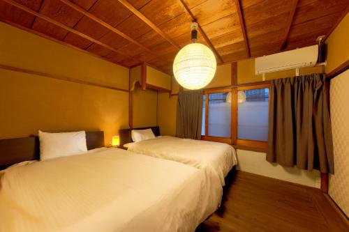 two beds in a room with a window at Nijo-Ouan in Kyoto