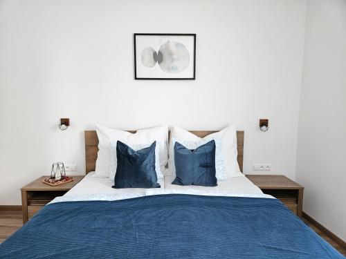 a bedroom with a blue and white bed with blue pillows at Brick House Residence in Poprad
