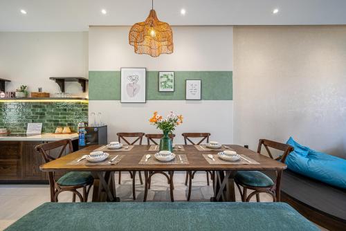a dining room with a wooden table and chairs at AnnA Home Novaworld Phan Thiết in Bình Tú