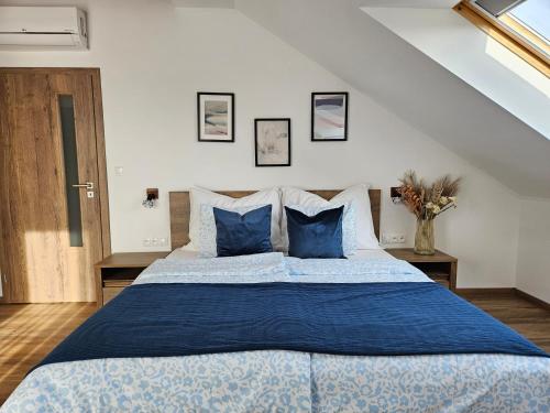 a bedroom with a large bed with blue pillows at Brick House Residence in Poprad