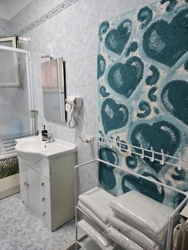 a bathroom with a sink and a shower with a wall at Family Home Casa Vacanze in Portici
