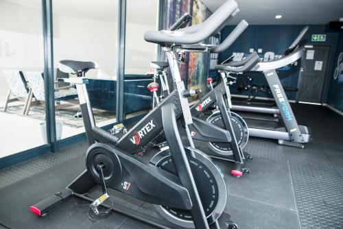a row of exercise bikes in a gym at Eirini Elegant - Hermes Apartment in Midrand