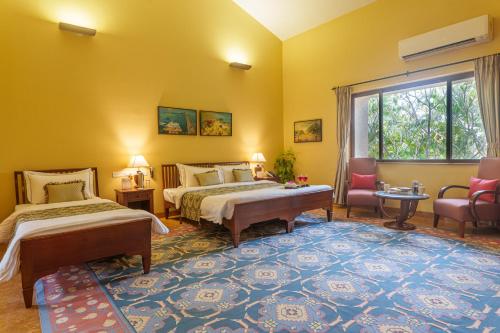 a hotel room with two beds and a window at amã Stays & Trails Kihim Courtyard, Alibag in Alibag