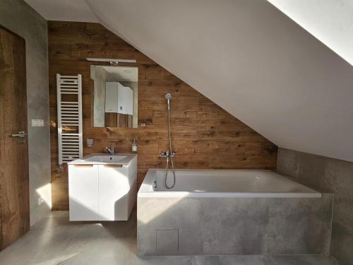 a bathroom with a bath tub and a sink at Brick House Residence in Poprad