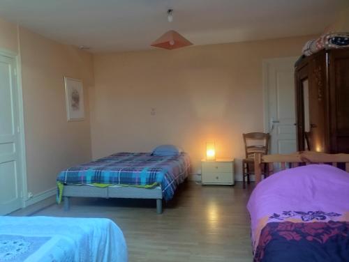 une chambre avec deux lits, une table et une lampe dans l'établissement Gite Paray le monial, à Paray-le-Monial