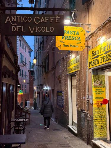 a person walking down a street under a sign at Bel Fiore Deluxe Apartment in Genova