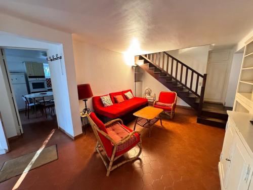 - un salon avec un canapé et des fauteuils rouges dans l'établissement La Ferme, agréable gîte en pleine nature, à Hyères