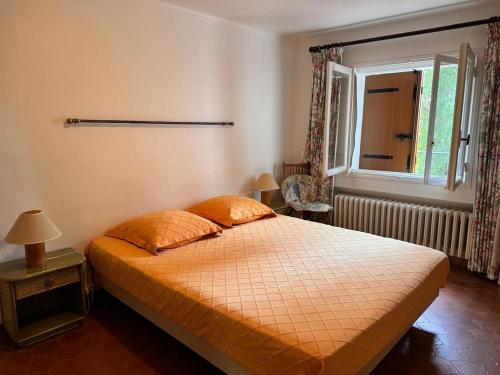 une chambre avec un lit et une fenêtre dans l'établissement La Ferme, agréable gîte en pleine nature, à Hyères