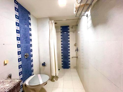 a bathroom with a toilet and blue and white tiles at Hyson heritage calicut in Kozhikode