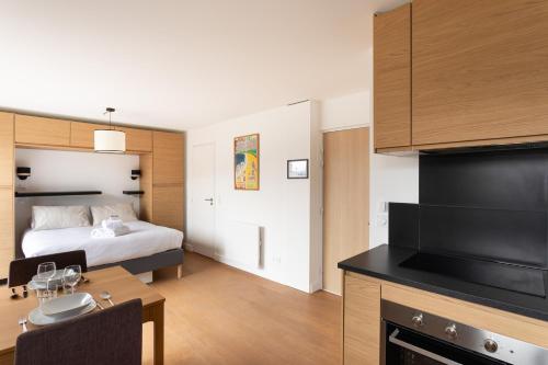 une chambre d'hôtel avec un lit, un bureau et une cuisine dans l'établissement La Studette - A 100 mètres de la plage, à Pléneuf-Val-André