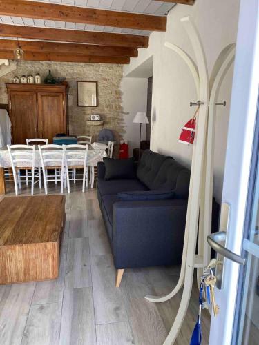 un salon avec un canapé bleu et une table dans l'établissement Maison 3 chambres 8 couchages plage à pied!, à Saint-Pierre-dʼOléron