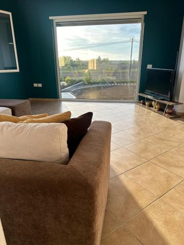 a living room with a couch and a large window at 3A villa in Rrushkull