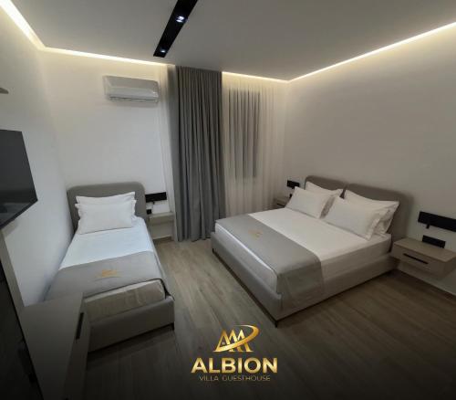 a hotel room with two beds and a television at Villa Guesthouse Albion in Lezhë